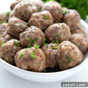 A white oval dish filled with keto meatballs for meal prep.