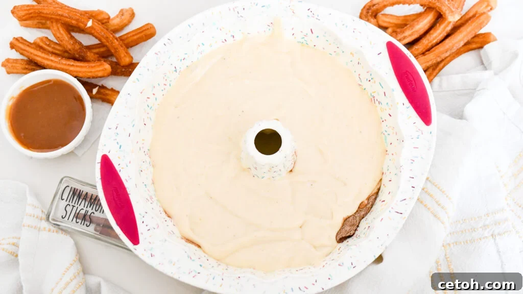 Cinnamon Sugar Delight Cake 6 Delicious Churro Bundt Cake slice showing the cinnamon swirl inside, with a generous caramel drizzle and a sprinkle of cinnamon sugar.