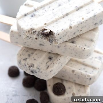 Close up shot of a stack of keto cookies and cream popsicles with a bite taken out of the top one.