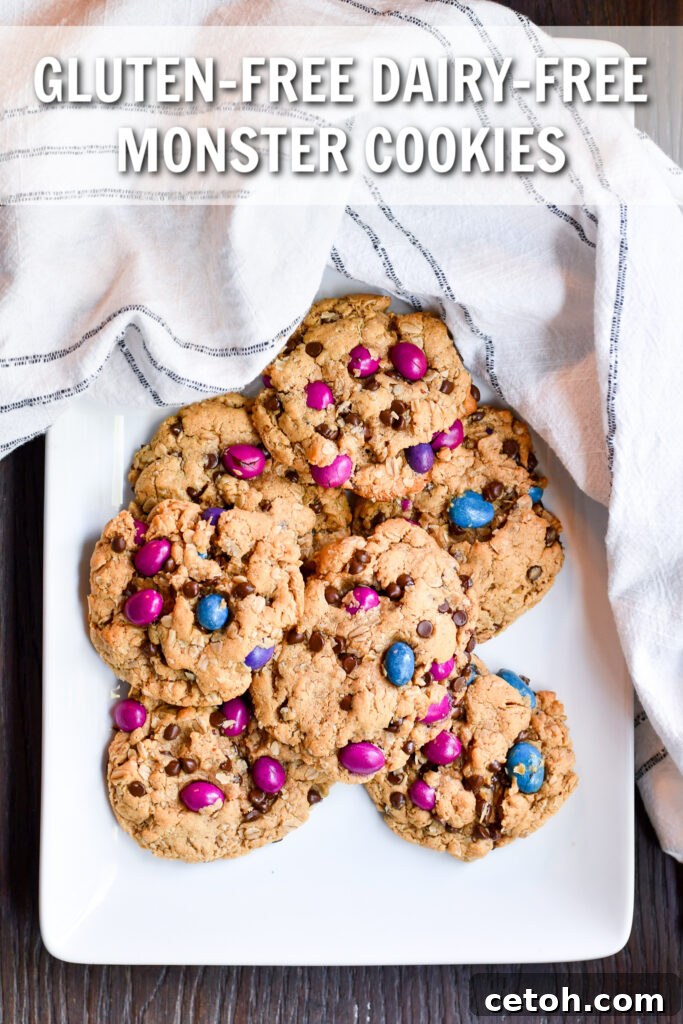A close-up shot of a plate of freshly baked gluten-free dairy-free monster cookies, showcasing their chewy texture, chocolate chips, and colorful candies.