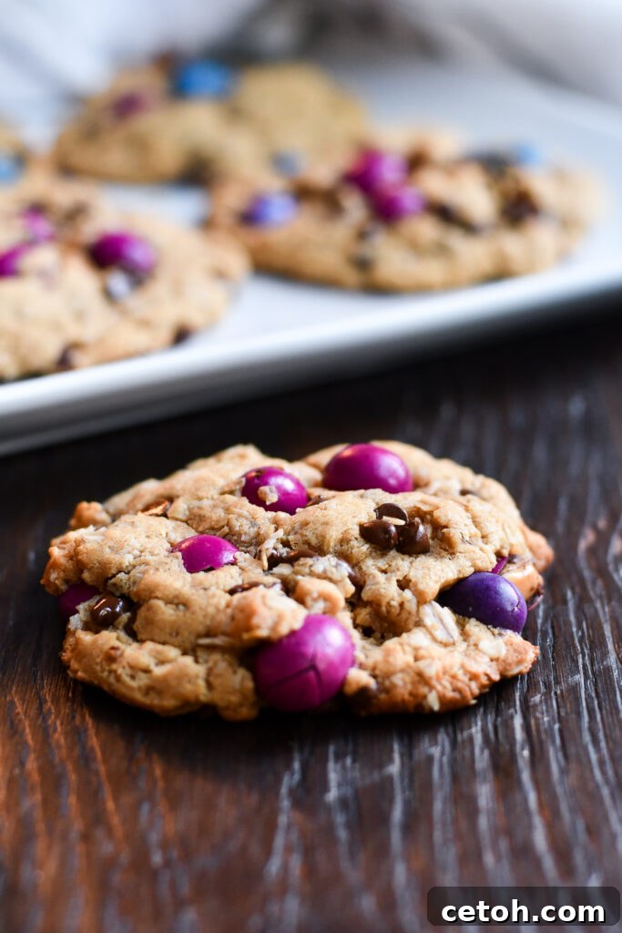 A cooling rack with several warm gluten-free dairy-free monster cookies, showcasing their golden edges and soft centers.