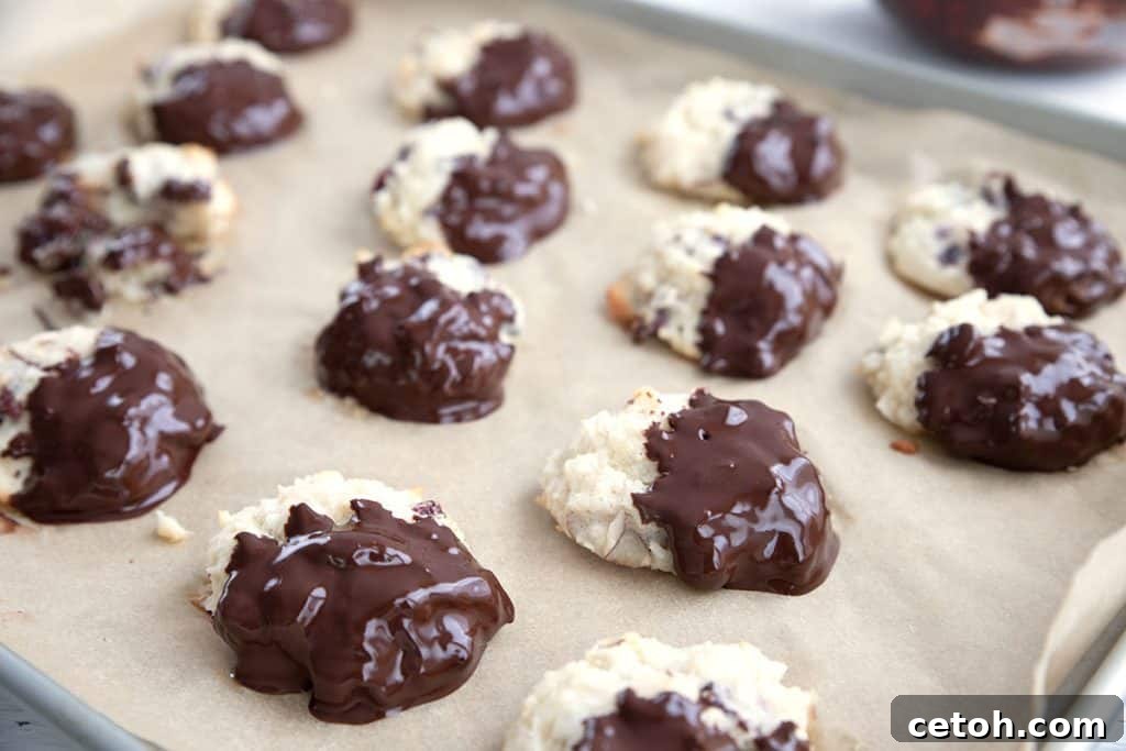 Delectable keto macaroons, freshly dipped in rich dark chocolate, arranged invitingly.