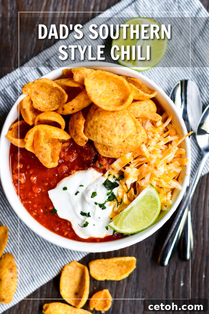A bowl of rich Dad's Southern Homemade Chili, topped with fresh green onions and shredded cheese, ready to be enjoyed. This award-winning comfort food recipe is perfect for fall and family gatherings.