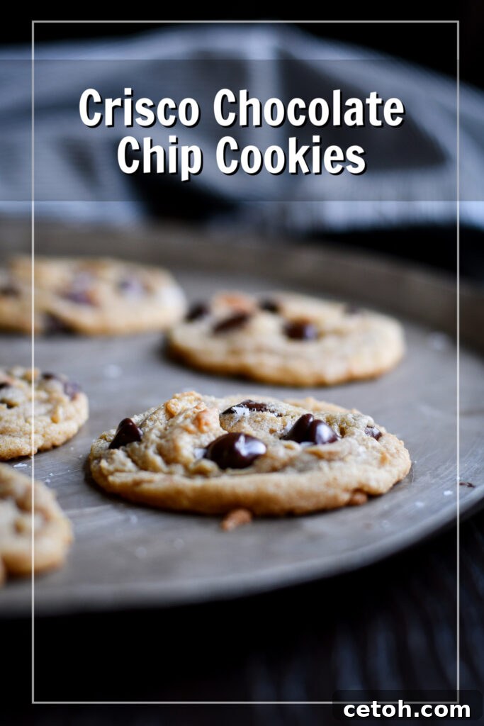 Freshly baked crispy edge chocolate chip cookies cooling on a wire rack, showcasing their golden-brown color and melting chocolate chips.