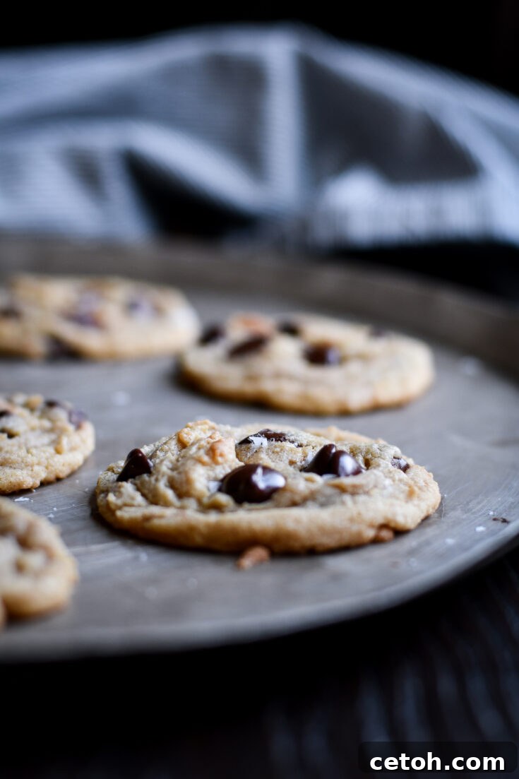 Stacked crispy edge chocolate chip cookies with a light dusting of sea salt.