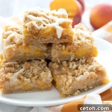 A pile of keto peach cobbler bars on a white plate over an orange plaid napkin.