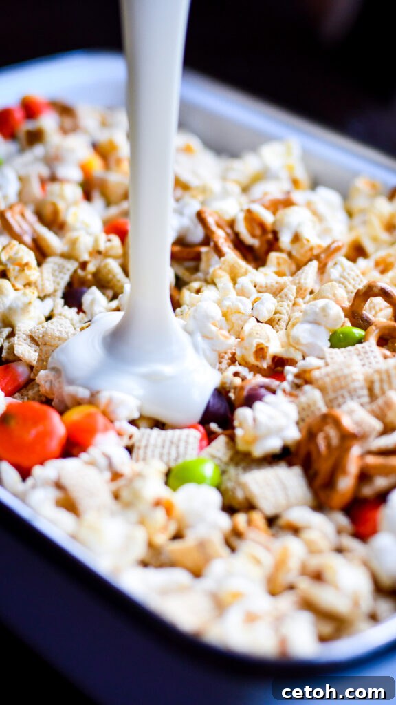 Easy Halloween Popcorn Treat with Candy Corn 3 Get into the Halloween spirit with this irresistible Popcorn Snack Mix, featuring a delightful mix of sweet and savory elements.