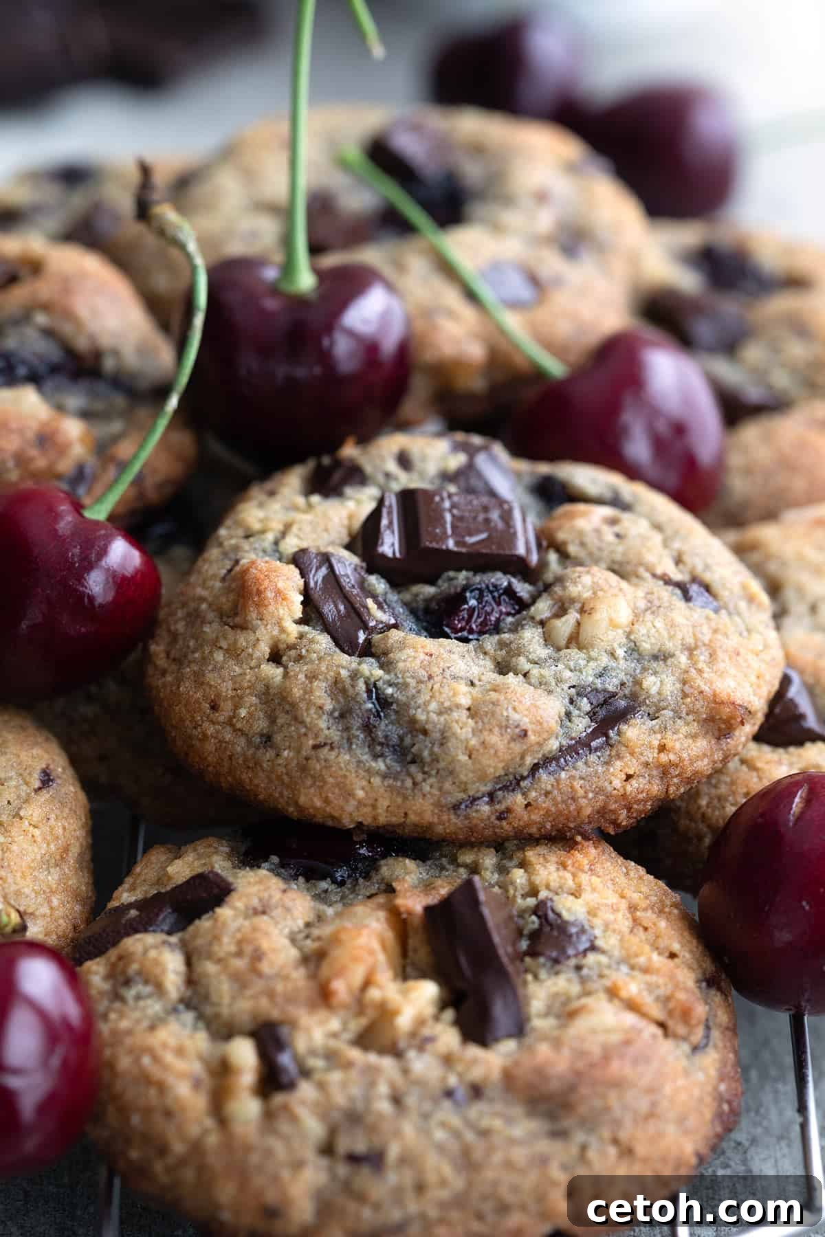Decadent Keto Cherry Chocolate Chunk Cookies 6 Close up shot of a pile of Cherry Chocolate Chunk Cookies on a cooling rack.