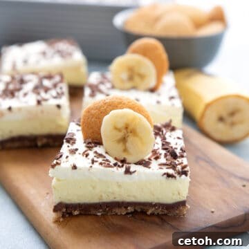 Keto Banana Cream Dream Bars 2 Keto Banana Cream Pie Bars on a wooden cutting board, ready to be served.
