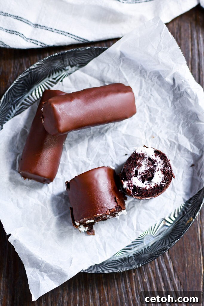 Unlock the secrets to recreating the iconic Swiss roll cake at home with this simple homemade recipe. Dive into a world of soft chocolate sponge and creamy marshmallow goodness, coated in rich chocolate.