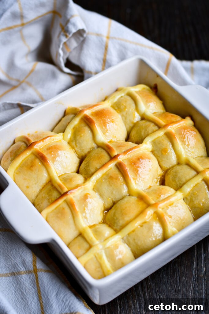 Love hot cross buns but not a fan of raisins? Try this soft & fluffy homemade hot cross buns recipe with warm cinnamon, an apricot glaze, and a cheesecake-style pastry cream cross baked right in! Perfect for Easter brunch or a sweet treat anytime.