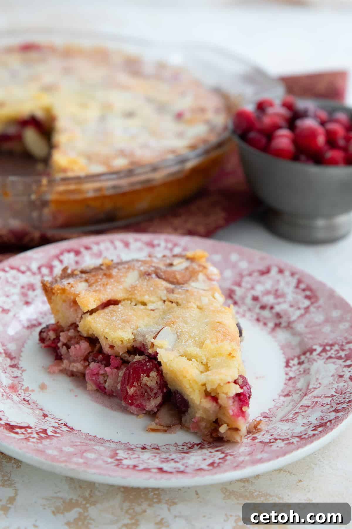 A slice of keto cranberry pie on a red patterned plate.