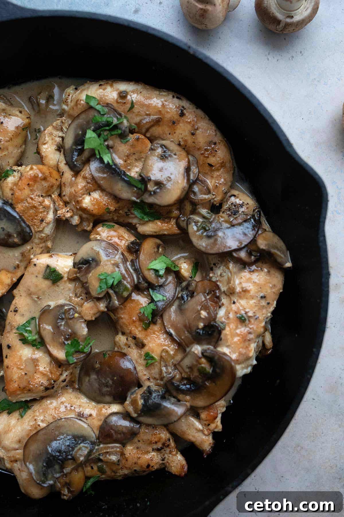 A close-up shot of rich and savory keto Chicken Marsala simmering perfectly in a pan, showcasing tender chicken and luscious sauce.