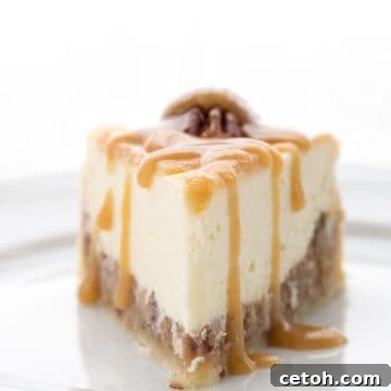 A slice of Keto Pecan Pie Cheesecake on a white plate with keto caramel sauce drizzled over.