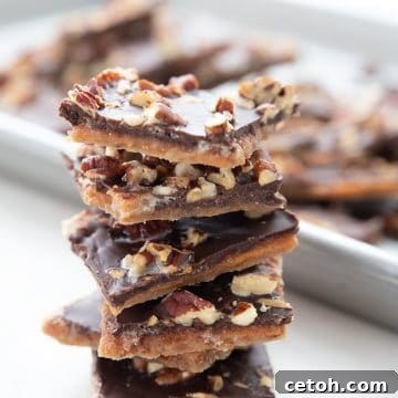 Guiltless Keto Toffee Indulgence 2 A stack of sugar free toffee in front of a pan with more broken pieces of toffee.