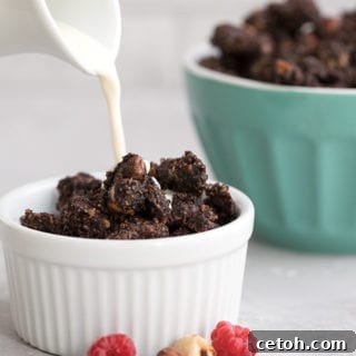 Cream being poured over a bowl of low carb chocolate granola