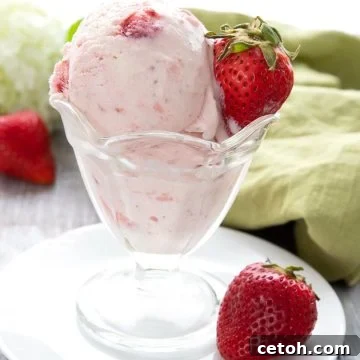 Keto strawberry ice cream in a glass dish in front of a green napkin.
