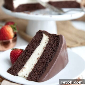 A slice of Keto Ding Dong Cake on a white plate in front of the rest of the cake.