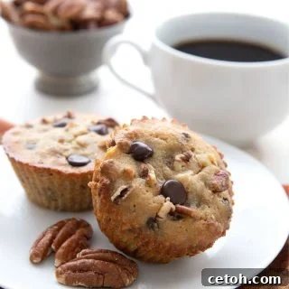 Keto Pecan Bliss Muffins 2 Titled image of keto pecan pie muffins on a white plate with a cup of coffee in behind.