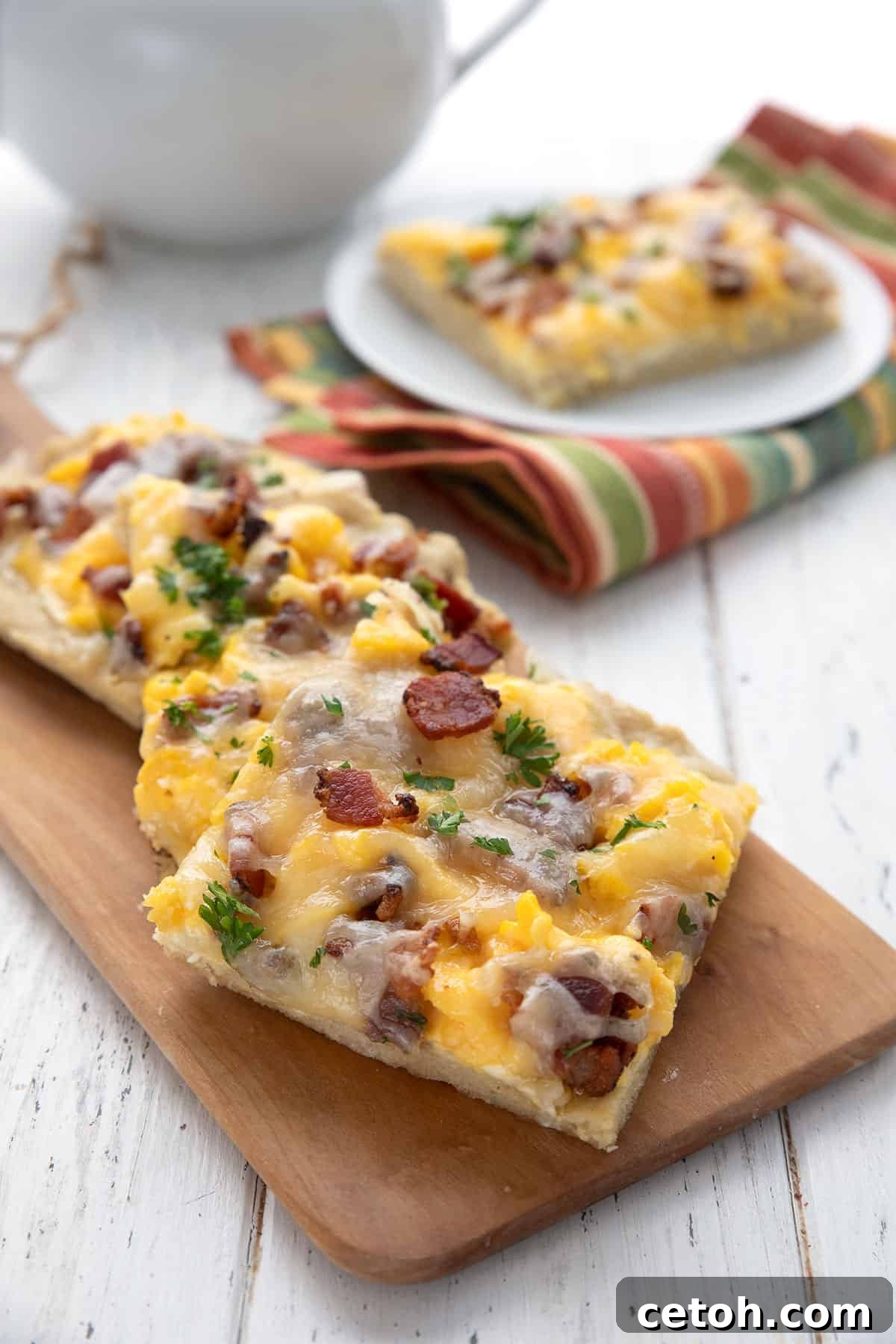 Three slices of keto breakfast pizza on a wooden cutting board.