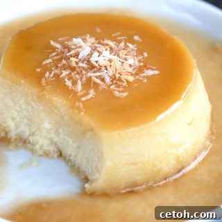 Close up shot of keto flan on a white plate with a few spoonfuls taken out of it.