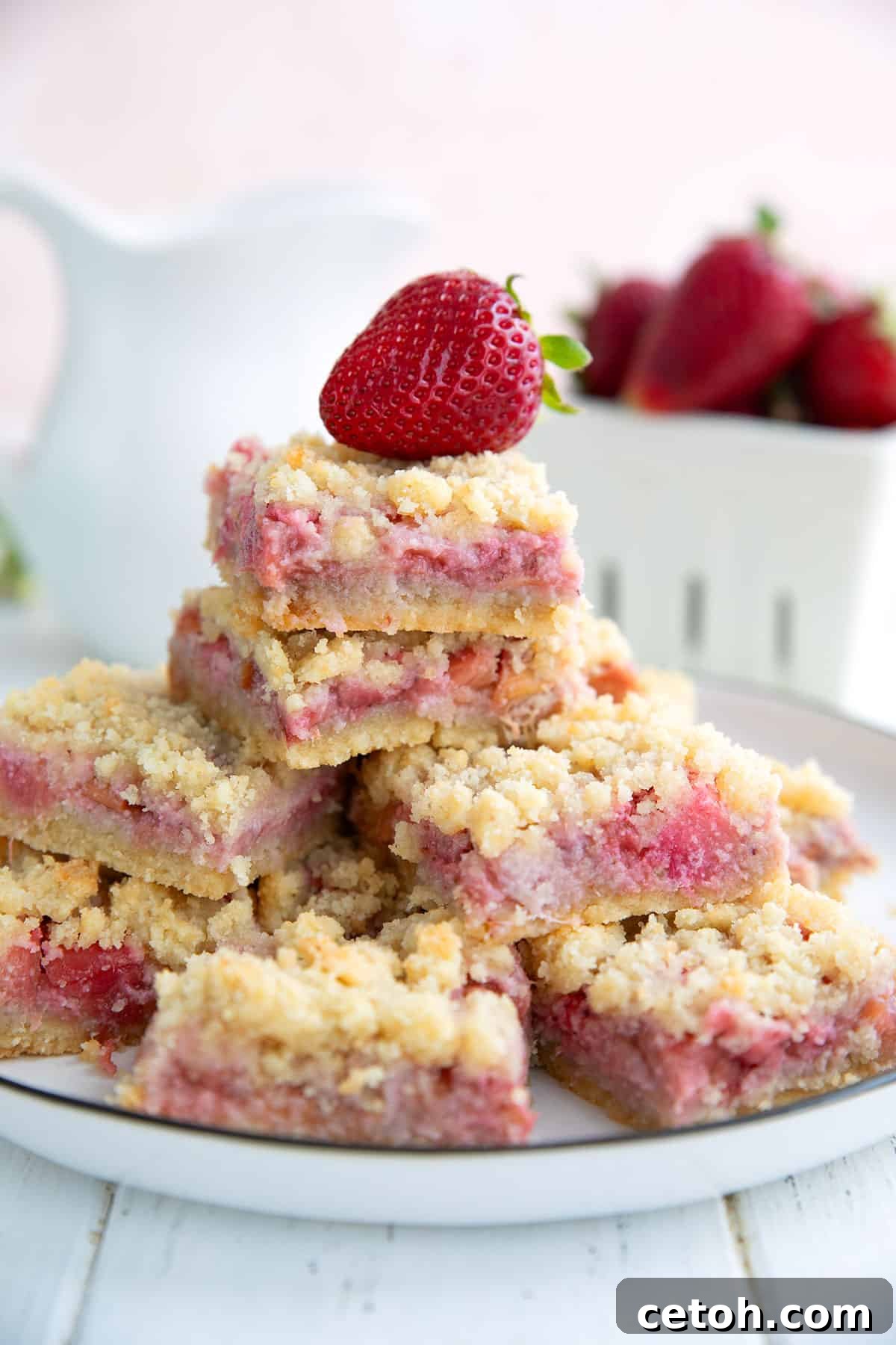 Keto strawberry rhubarb crumb bars on a white plate on a white table.