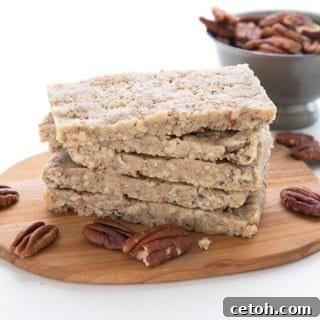 Keto pecan pie protein bars in a stack on a small cutting board