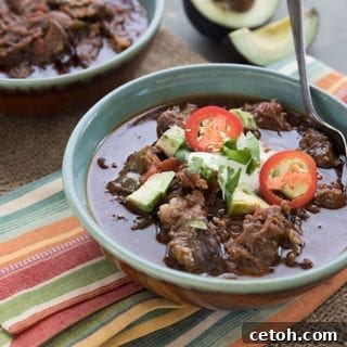 Decadent Keto Short Rib Chili 2 A bowl of keto short rib chii topped with sour cream, cilantro, avocado and jalapeno