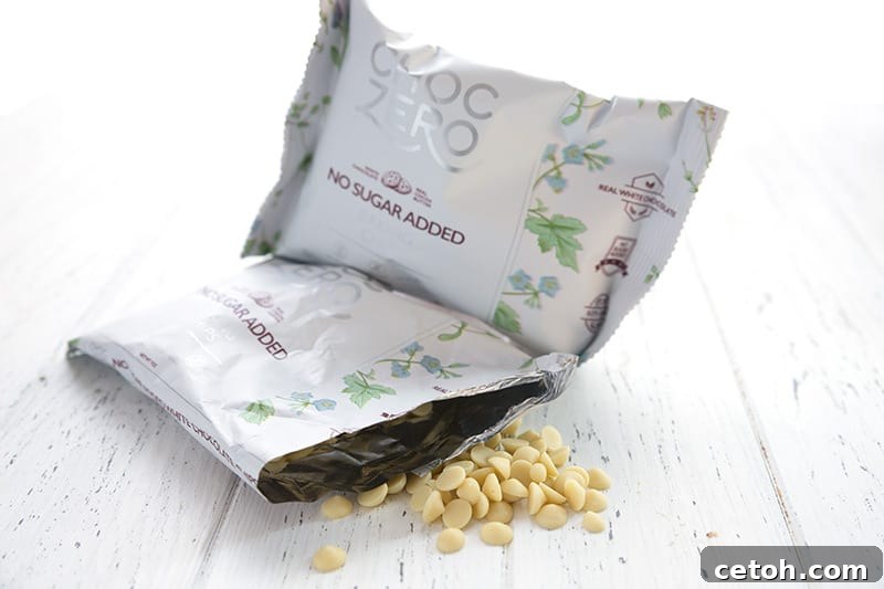 Two bags of keto white chocolate chips, with the delicious chips spilling out of one bag, showcasing their quality.