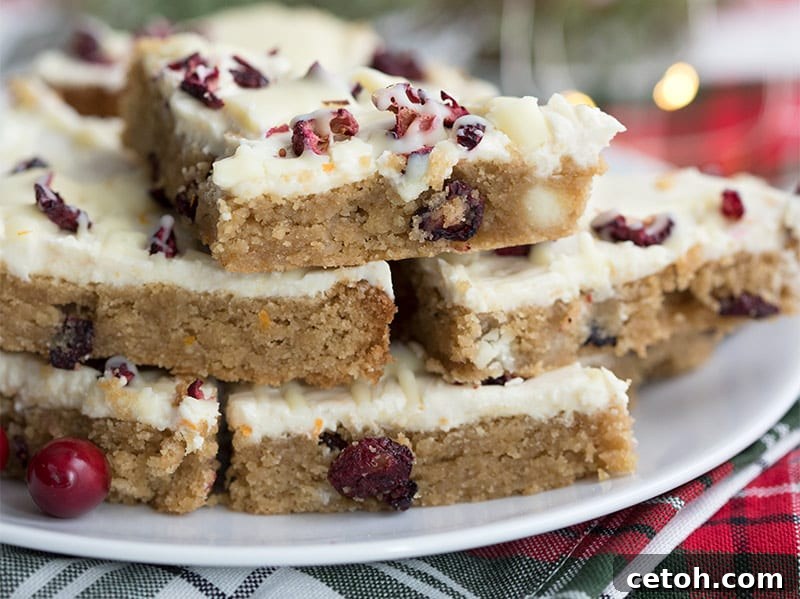 A charming stack of keto cranberry bliss bars arranged on a festive holiday plaid napkin, ready to be enjoyed.