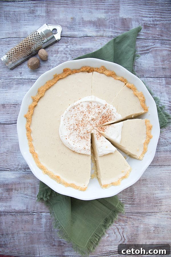 Top down photo of eggnog cream pie in a white pie plate on a green napkin, showing the beautiful creamy texture.