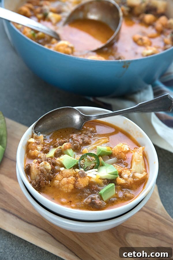 A bowl full of keto chili mac with avocado and sliced jalapeño.
