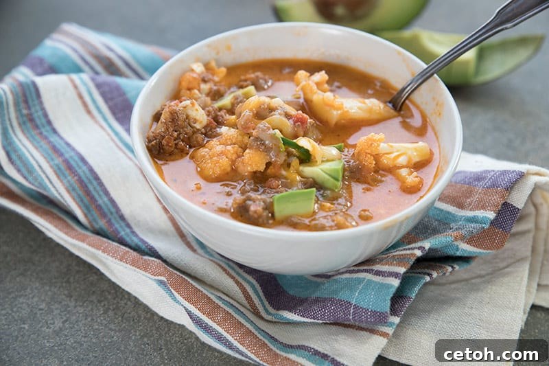 A white bowl filled with keto-friendly chili mac and cheese over a striped napkin.