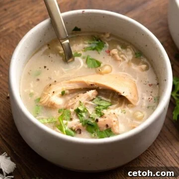Keto White Chicken Chili in a white bowl with a spoon in it.