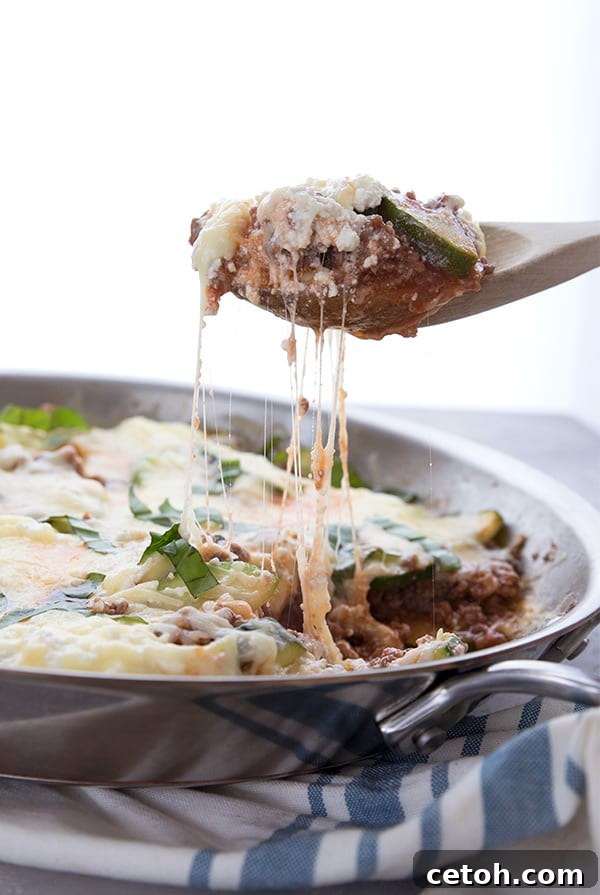 A scoopful of keto skillet lasagna being pulled away from the skillet