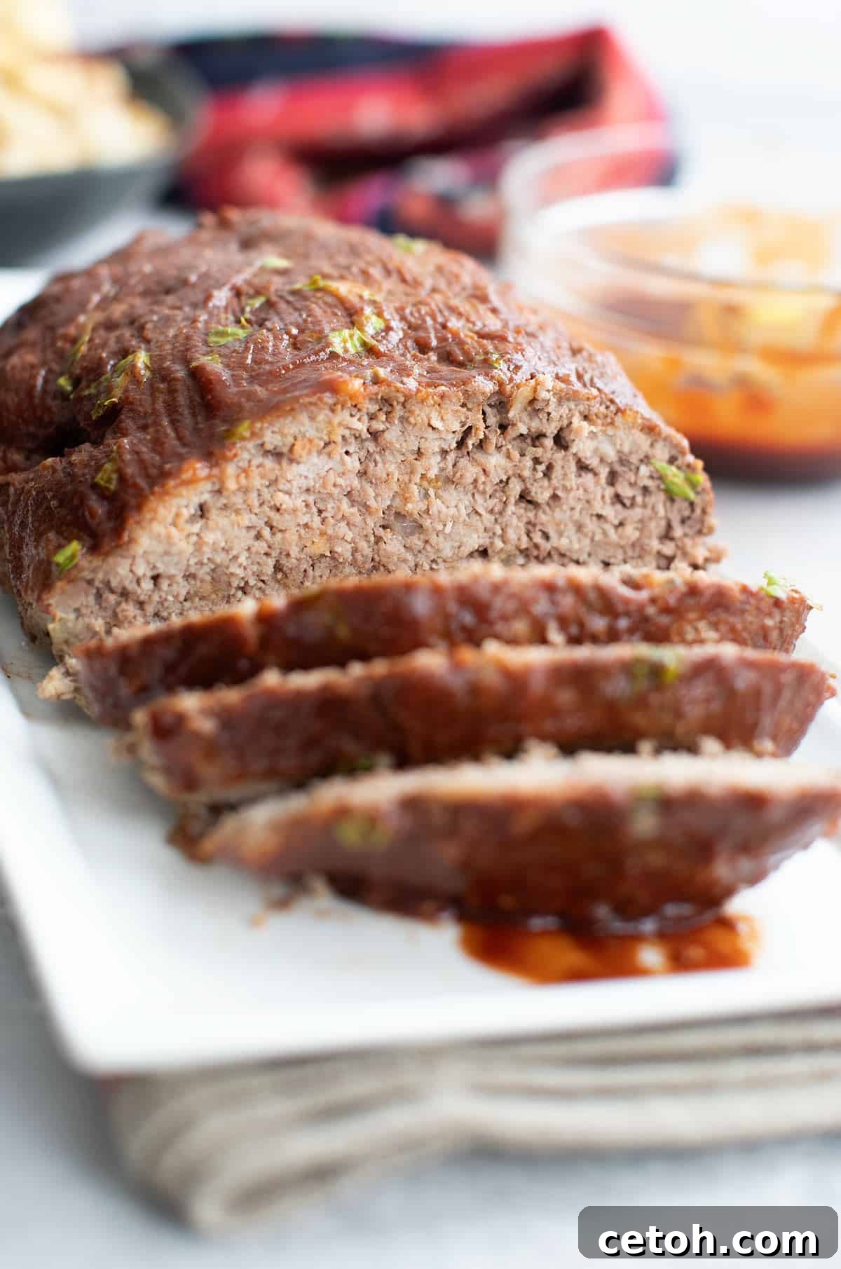 A white platter with keto meatloaf, with a few slices cut into the front.