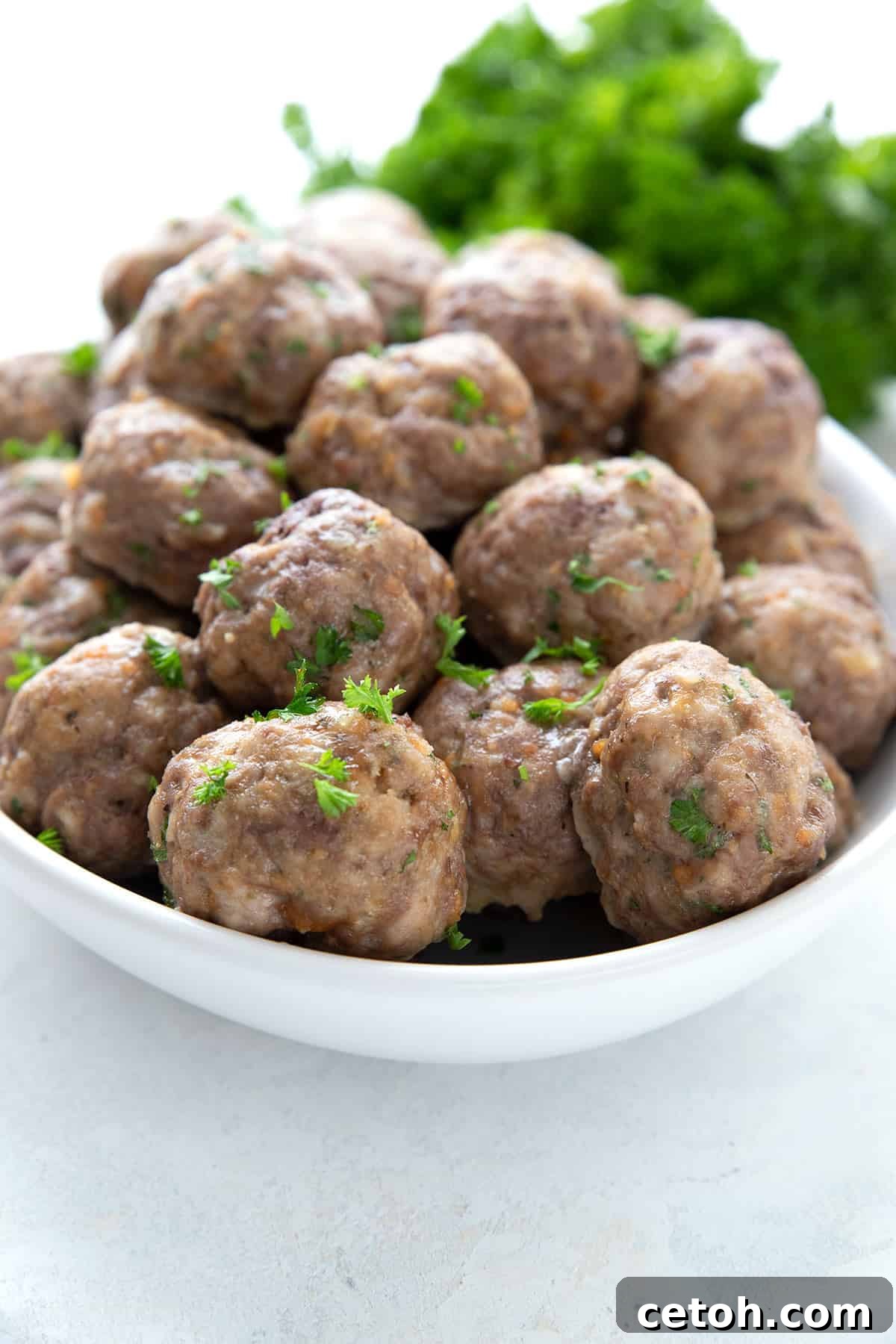 A white oval dish filled with keto meatballs for meal prep.