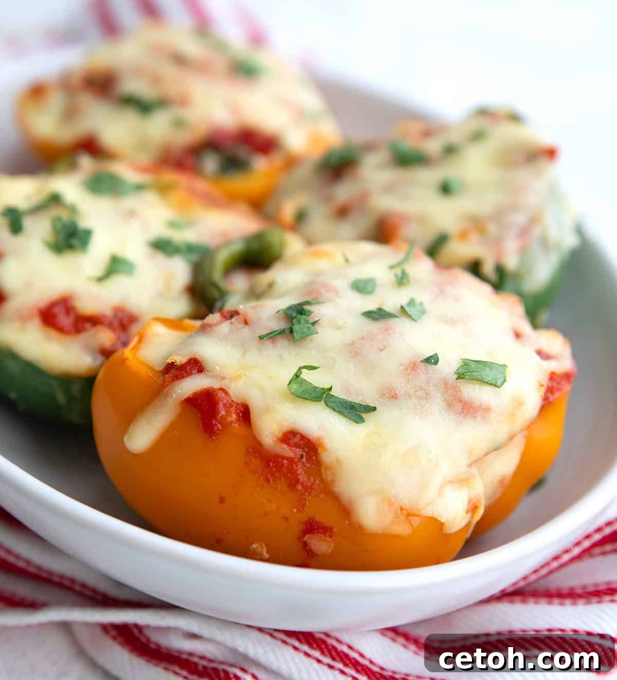 Close up shot of keto stuffed peppers in a white oval dish.