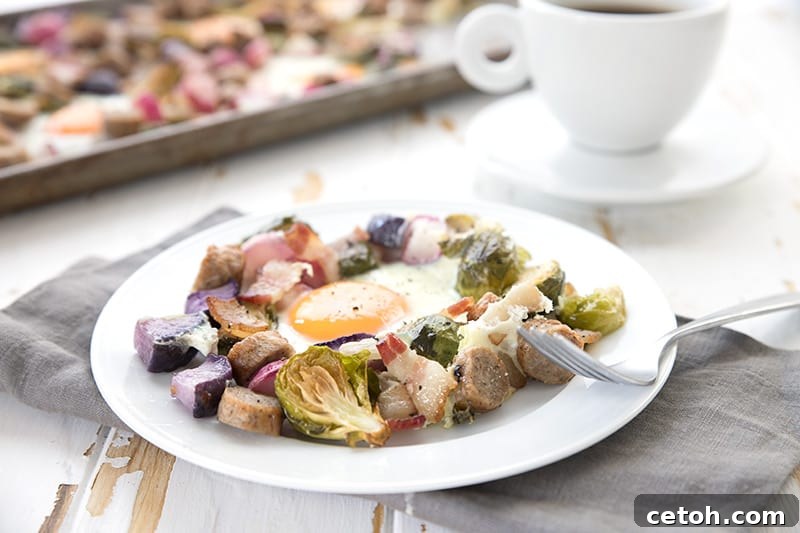 Sheet Pan Keto Morning Delight 3 A serving of eggs and veggies sheet pan meal on a white plate with the rest of the sheet pan in the background