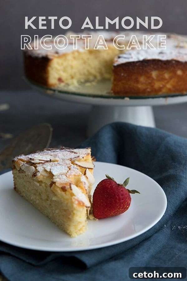 Titled image of keto almond ricotta cake. A slice of cake on a white plate with a strawberry, the rest of the cake on a stand in the background.
