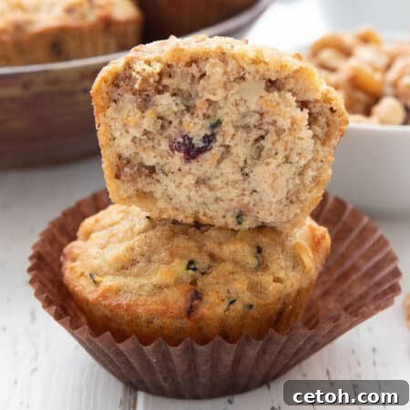 Close up shot of half of a keto morning glory muffin stacked up on another muffin, showing the interior texture.