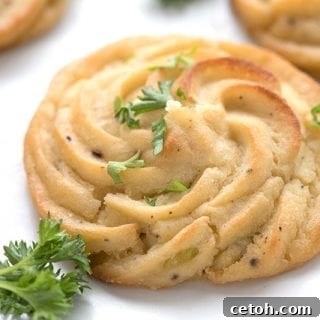 Close up shot of keto duchess cauliflower on a white plate with parsley