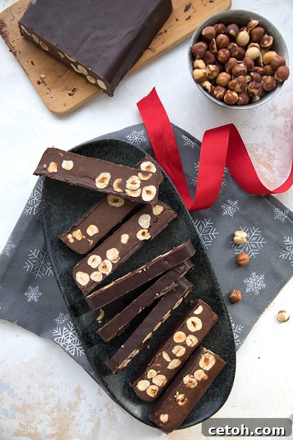 Top down photo of keto chocolate torrone in slices on an oval platter, over a grey napkin with snowflakes