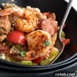 Titled image of keto jambalaya in a black bowl with a fork.