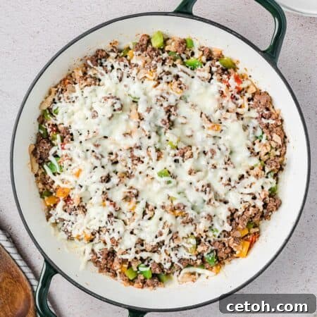 Top down image of Keto Stuffed Pepper Skillet in a large enameled pan with two handles, ready for serving.