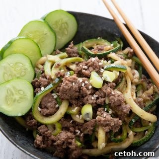 Titled image of a bowl of keto Korean beef with zucchini noodles and chopsticks on the side.