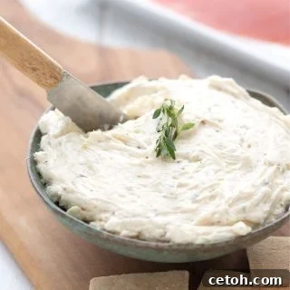 Close up shot of homemade Boursin cheese in a green bowl with keto crackers around it.