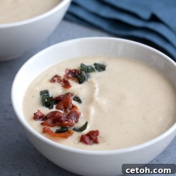 Close up shot of roasted cauliflower soup with crispy prosciutto and sage on top.