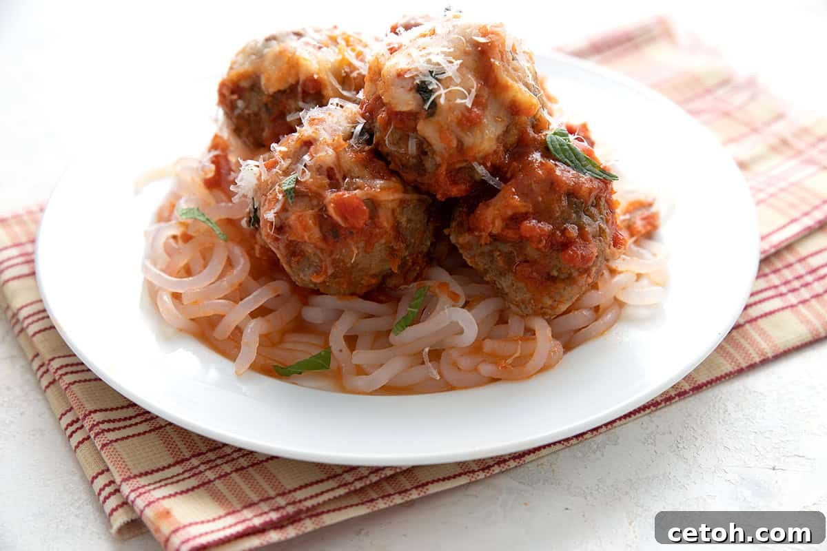 A white plate with keto meatball casserole on top of shiritaki noodles.