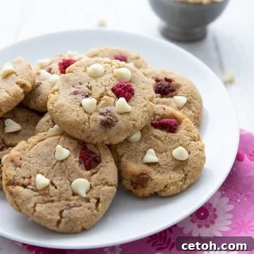 Keto raspberry cheesecake cookies on a white plate over a pink patterned napkin.